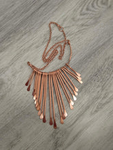 Load image into Gallery viewer, A Pure Copper statement necklace featuring multiple thin bar elements fanning out from a central chain, displayed on a gray wood-textured background.