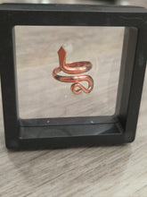 Load image into Gallery viewer, A copper snake-shaped ring displayed inside a black square shadow box on a light wood surface.