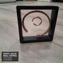 Load image into Gallery viewer, Copper spiral art piece in a black frame on a wooden surface
